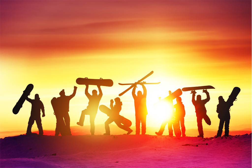 Snowboardergruppe freut sich bei Sonnenuntergang