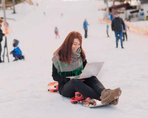 Frau im Schnee am Laptop